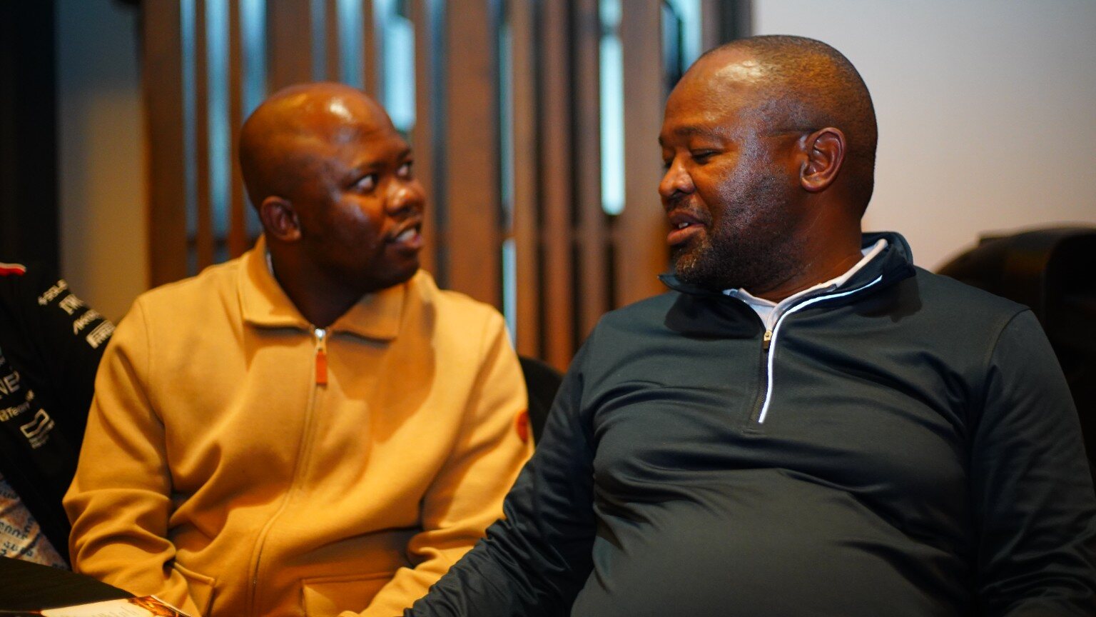 Candid event photograph of two guests in conversation